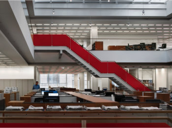 Interior photo showing two open levels of an office in New York City with a staircase between them
